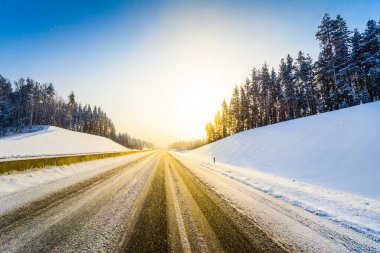 Açık bir kış sabahında gün doğumu, karda boş otoyollar.  