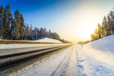 Açık bir kış sabahında gün doğumu, karda boş otoyollar.  