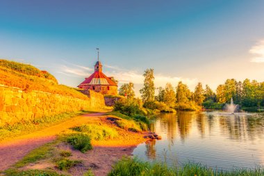 Nehir kıyısındaki ortaçağ kalesi. Gün batımı. Orman. Mavi gökyüzü.