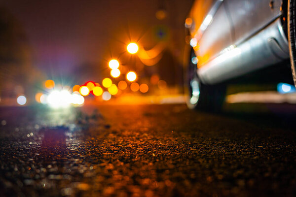 Night country road with glowing lanterns. Headlights of approach