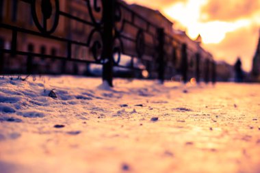 Büyük bir şehirde parlak kış güneşi, insanlar sokakta yürüyor..