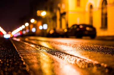 Büyük şehirde yağmurlu bir gece, su birikintileri olan boş bir yol.