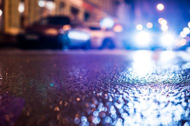 Büyük şehirde yağmurlu bir gece, su birikintileri olan boş bir yol.