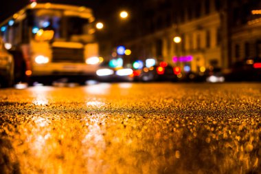 Büyük şehirde yağmurlu bir gece, su birikintileri olan boş bir yol.