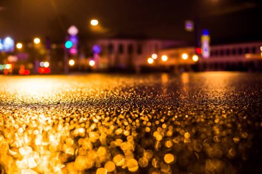 Büyük şehirde yağmurlu bir gece, su birikintileri olan boş bir yol.