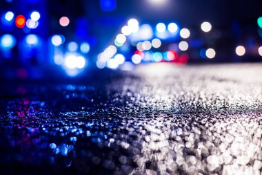 Büyük şehirde yağmurlu bir gece, su birikintileri olan boş bir yol.