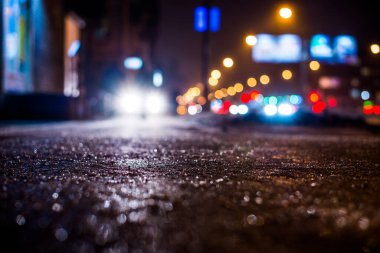 Büyük şehirde yağmurlu bir gece, parlak vitrinleri olan bir cadde. 