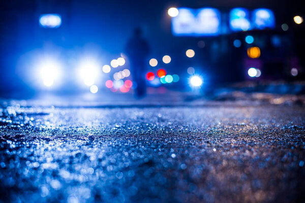 Rainy night in the big city, the street with bright shop windows 