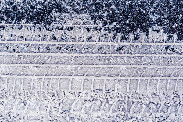 アスファルト上の新鮮な雪の中で車のタイヤのトレース ビューを閉じる — ストック写真