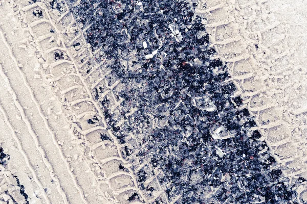 アスファルト上の雪の中で車のタイヤの図の痕跡 — ストック写真