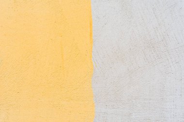 Sarı, pürüzlü, beyaz bir duvara boyanmış. Görüntüyü kapat