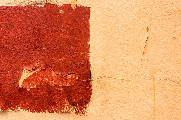 Red rectangle on an old orange wall. Close up view