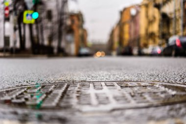 Büyük şehirde yağmurlu bir gün, boş bir yolda park edilmiş arabalar..