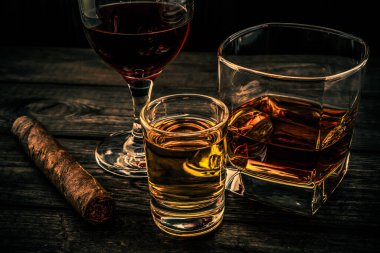 Üç bardak brendi, tekila ve Küba purosuyla kırmızı şarap.