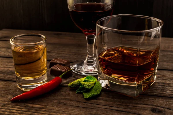 Três Copos Com Conhaque Tequila Vinho Tinto Mesa Madeira — Fotografia de Stock