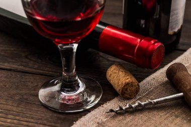 İki şişe kırmızı şarap ve bir kadeh kırmızı şarap.