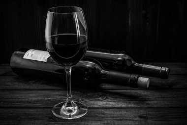 Eski ahşap bir masada iki şişe kırmızı şarap.. 