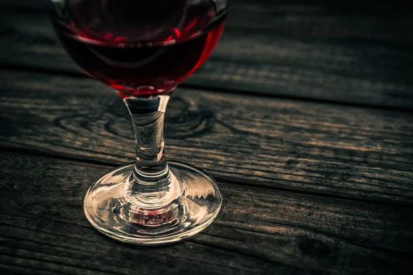 古い木製のテーブルの上に赤ワインのガラス ビューを閉じる — ストック写真