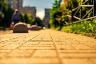 Şehirde güneşli bir gün, park halindeki arabalarla şehir avlusunda yol.