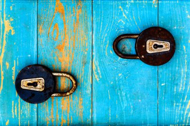 Eski ahşap masada iki eski ve paslı asma kilit.