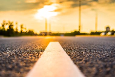 Şehirde gün batımı, otoyolda yaklaşan minibüs. Kapat.