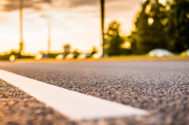 Şehirde gün batımı, otoyolda yaklaşan minibüs. Kapat.