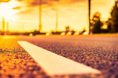 Şehirde gün batımı, otoyolda yaklaşan minibüs. Kapat.