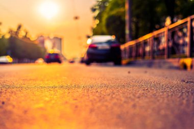 Şehirde gün batımı, otoyolda yaklaşan minibüs. Kapat.