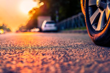 Şehirde gün batımı, otoyolda yaklaşan minibüs. Kapat.