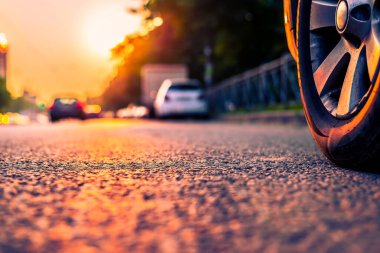 Şehirde gün batımı, otoyolda yaklaşan minibüs. Kapat.