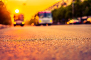 Şehirde gün batımı, otoyolda yaklaşan minibüs. Kapat.