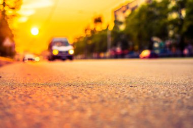 Şehirde gün batımı, otoyolda yaklaşan minibüs. Kapat.