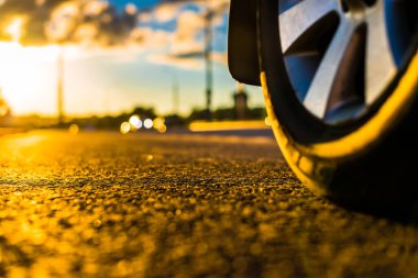 Yağmurdan sonra gün batımı, yolda yaklaşan arabanın farları...