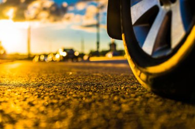 Yağmurdan sonra gün batımı, yolda yaklaşan arabanın farları...