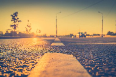 Yağmurdan sonra gün batımı, yolda yaklaşan arabanın farları...