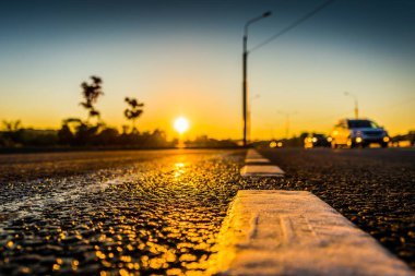 Sunset after rain, sun reflecting in wet road surface