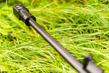 Güz çimlerinde sabah çiğ taneleriyle kaplanmış bir tüfeği nişan almak.