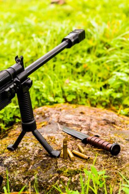 Bir çift ayaklı tüfek ve boş kovanlı savaş bıçağı.