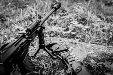 Tüfek bir bipod üzerinde duruyor, açık deri bandoyla.