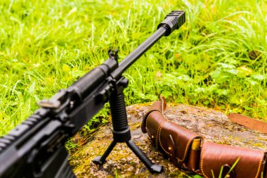 Tüfek bir bipod üzerinde duruyor, deri bandoyla.