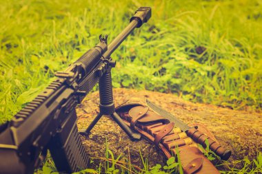 Tüfek bir bipod üzerinde duruyor, açık deri bandoyla.