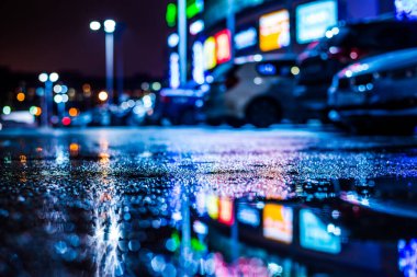 Büyük şehirde yağmurlu bir gece, su birikintileri olan boş bir yol.