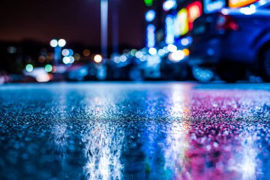 Büyük şehirde yağmurlu bir gece, su birikintileri olan boş bir yol.