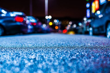 Büyük şehirde yağmurlu bir gece, su birikintileri olan boş bir yol.