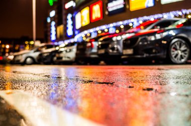 Büyük şehirde yağmurlu bir gece, su birikintileri olan boş bir yol.