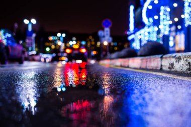 Rainy night in the big city, the empty road with puddles clipart