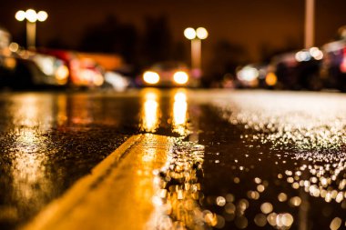 Büyük şehirde yağmurlu bir gece, su birikintileri olan boş bir yol.