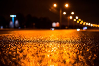 Büyük şehirde yağmurlu bir gece, su birikintileri olan boş bir yol.