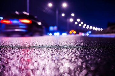 Büyük şehirde yağmurlu bir gece, parlak vitrinleri olan bir cadde. 