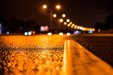 Büyük şehirde yağmurlu bir gece, su birikintileri olan boş bir yol.